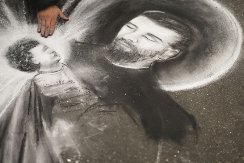 Ariel Robledo dibuja una imagen de San Cayetano afuera de la iglesia católica de San Cayetano durante una peregrinación anual en honor al santo patrón del trabajo en Buenos Aires, Argentina, el jueves 7 de agosto de 2025. (AP Foto/Natacha Pisarenko)