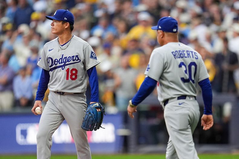 Dave Roberts (30), mánager de los Dodgers de Los Ángeles, saca del partido al abridor Yoshinobu Yamamoto (18) durante la tercera entrada del Juego 2 de la Serie de Campeonato de la Liga Nacional ante los Cerveceros de Milwaukee, el lunes 12 de octubre de 2026, en Milwaukee. (AP Foto/Abbie Parr)