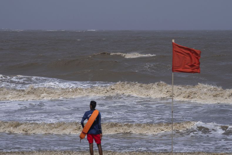 Un socorrista vigila la costa en la playa desierta de Juhu, en Mumbai, India, el 13 de junio de 2023. (AP Foto/Rafiq Maqbool)