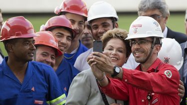americateve | Trabahadores de la construcci&oacute;n se toman una fotograf&iacute;a con la presidenta brasile&ntilde;a Dilma Rousseff durante la visita de ella al estadio Itaquerao, en Sao Paulo, el jueves 8 de mayo de 2014. (Foto AP/Andre Penner)