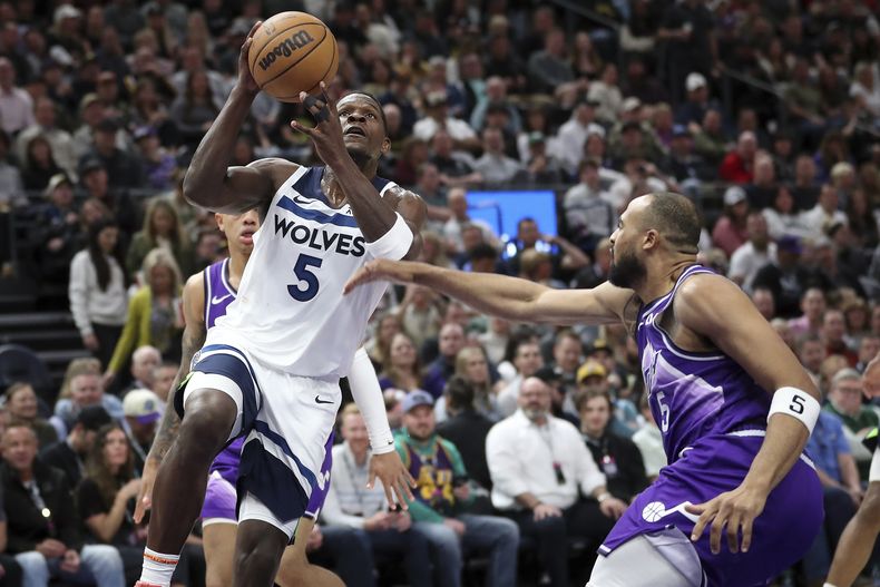 Anthony Edwards, izquierda, de los Timberwolves de Minnesota, ataca la canasta superando la presión defensiva de Talen Horton-Tucker, del Jazz de Utah, durante la segunda mitad del juego de baloncesto de la NBA, el lunes 18 de marzo de 2024, en Salt Lake City. (AP Foto/Adam Fondren)