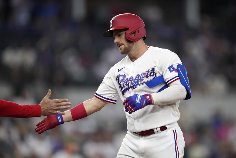Robbie Grossman, de los Rangers de Texas, festeja tras conectar un sencillo productor ante los Rockies de Colorado, el sábado 20 de mayo de 2023 (AP Foto/LM Otero)