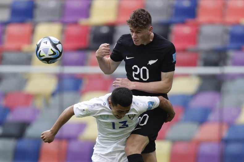 Lukas Kelly-Heald de Nueva Zelanda salta para cabecear ante Zafarmurod Abdirakhmatov de Uzbekistan durante un partido del Grupo A del Mundial Sub20 de Argentina en el estadio Madre de Ciudades de Santiago del Estero, Argentina, martes 23 mayo, 2023. (AP Foto/Nicolás Aguilera)