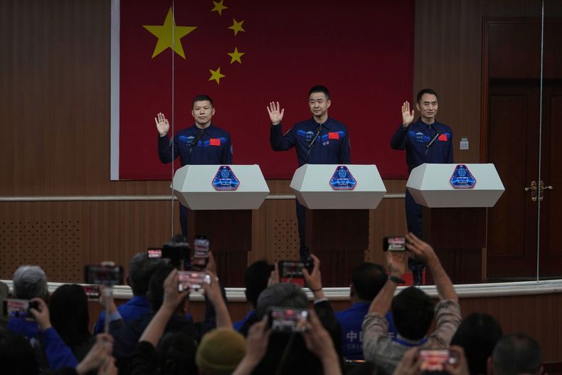 Periodistas graban con sus teléfonos a los astronautas chinos que partirán en la misión Shenzhou 20. De izquierda a derecha: Wang Jie, el capitán Chen Dong y Chen Zhongrui, el miércoles 23 de abril de 2025, en el Centro de Lanzamientos Satelitales Jiuquan, en el noroeste de China. (AP Foto/Andy Wong, Archivo)