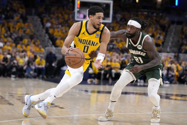 Tyrese Haliburton (0), de los Pacers de Indiana, encara la marca defensiva de Patrick Beverley (21), de los Bucks de Milwaukee, durante el Juego 6 de la serie de playoffs de primera ronda del baloncesto de la NBA, el jueves 2 de mayo de 2024, en Indianápolis. (AP Foto/Michael Conroy)