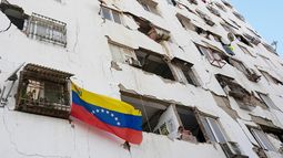 Una bandera venezolana cuelga de un edificio dañado por fuertes sismos en Catia La Mar, Venezuela, el viernes 26 de junio de 2026. (AP Foto/Fernando Vergara)