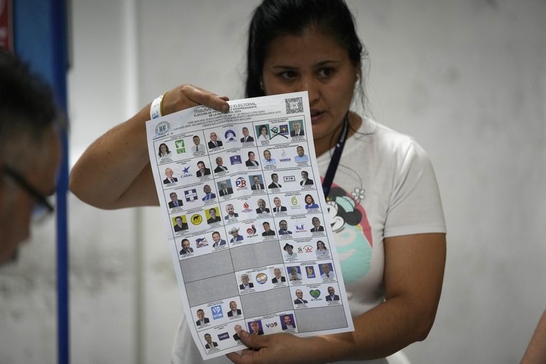 Una trabajadora electoral muestra un voto durante el conteo después del cierre de urnas en las elecciones generales en Ciudad de Guatemala, el domingo 25 de junio de 2023. (AP Foto/Moisés Castillo)