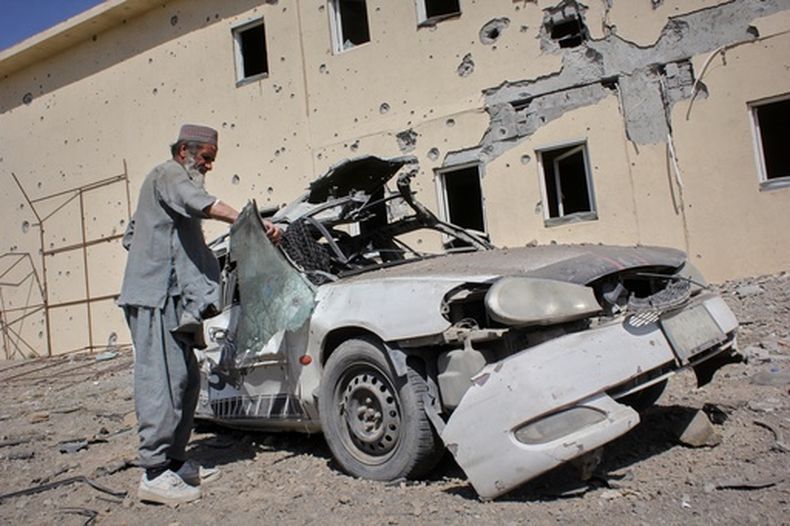 Un hombre inspecciona un coche dañado tras un ataque paquistaní en un campo de refugiados en el distrito de Takhta Pul, provincia de Kandahar, Afganistán, el 28 de febrero de 2026. (Foto AP/Sibghatullah)