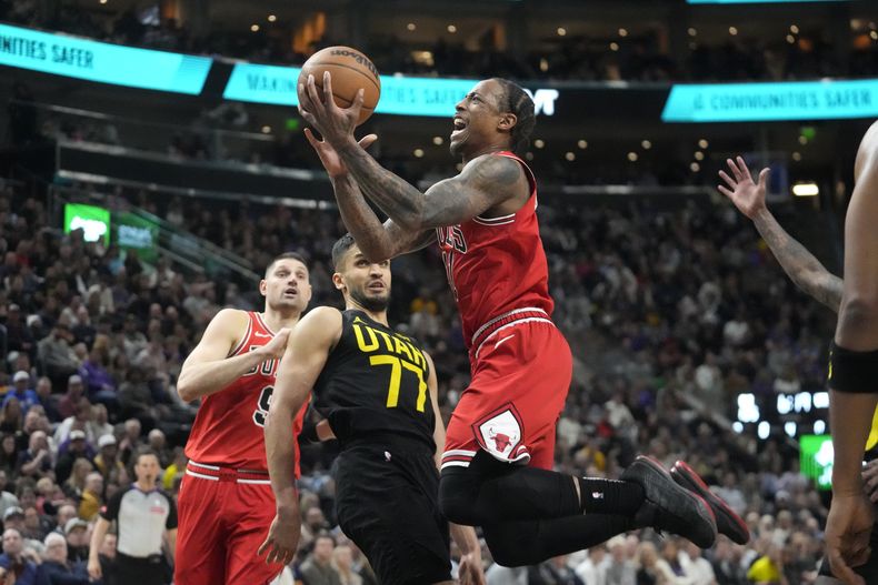 DeMar DeRozan, de los Bulls de Chicago, se alza rumbo a la canasta, mientras que Omer Yurtseven (77), del JAzz de Utah, observa durante la segunda mitad del juego de baloncesto de la NBA, el miércoles 6 de marzo de 2024, en Salt Lake City. (AP Foto/Rick Bowmer)