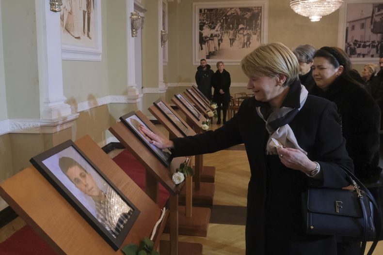 Personas ven fotos de familiares tras la ceremonia en conmemoración de víctimas de un tiroteo en Cetinje, a unos 30 kilómetros de Podgorica, Montenegro, el 4 de enero del 2025. (AP foto/Risto Bozovic)