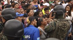 Amigos y familiares de presos esperan noticias de sus seres queridos tras los enfrentamientos con muertos en la Penitenciaría del Litoral de Guayaquil, Ecuador, el martes 25 de julio de 2023. Ecuador anunció el martes un estado de excepción en todo el sistema penitenciario después de una serie de violentos incidentes que incluyeron disparos y explosiones en la cárcel más grande y peligrosa del país. (AP Foto/César Muñoz)