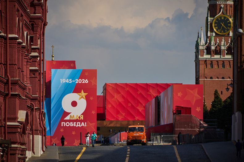 Varias personas pasan por delante de un cartel del Día de la Victoria, en una entrada cerrada a la Plaza Roja, decorada para la celebración del 81er aniversario de la victoria de la Unión Soviética sobre la Alemania nazi en la Segunda Guerra Mundial, en Moscú, Rusia, el 6 de mayo de 2026. (AP Foto/Alexander Zemlianichenko)