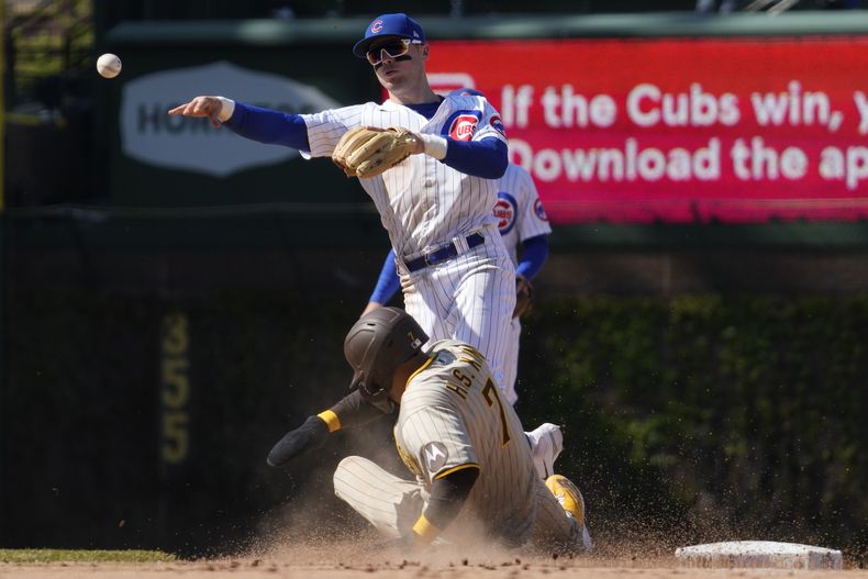 Nico Hoerner de los Cachorros de Chicago saca out en segunda base a Nelson Cruz de los Padres de San Diego, el jueves 27 de abril de 2023. (AP Foto/Nam Y. Huh)