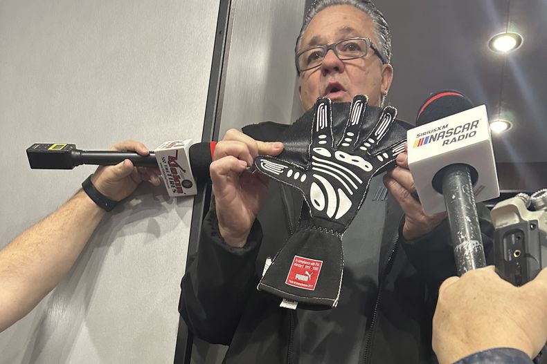 El director general de la NASCAR Cup Series, Brad Moran, muestra a los periodistas, el sábado 2 de marzo de 2024, en Las Vegas Motor Speedway, el guante ilegal que Joey Logano, del equipo Penske, fue sorprendido usando durante la clasificación la semana pasada en Atlanta Motor Speedway. Las correas entre los dedos se utilizan para bloquear el aire cuando un piloto saca la mano por la ventana durante la calificación. (AP Foto/Jenna Fryer)
