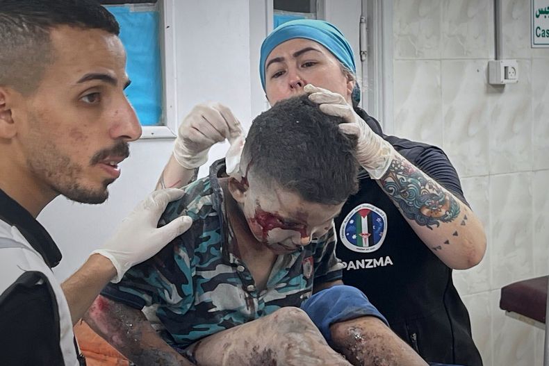 Esta foto, proporcionada por la enfermera estadounidense Andee Vaughan, derecha, muestra a Vaughan atendiendo a un niño con quemaduras graves tras un ataque del ejército israelí contra su casa, en el hospital Al-Quds de Ciudad de Gaza el 24 de julio de 2025. (Cortesía de Andee Vaughan vía AP)