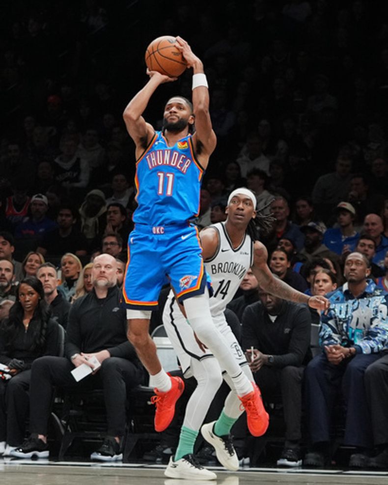 Isaiah Joe (11), del Thunder de Oklahoma City, dispara de larga distancia frente a Terance Mann (14), de los Nets de Brooklyn, durante la segunda mitad del juego de baloncesto de la NBA, el miércoles 18 de marzo de 2026, en Nueva York. (AP Foto/Frank Franklin II)