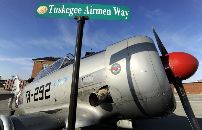 ARCHIVO - La señal de la calle Tuskegee Airmen Way se muestra brevemente frente a un avión North American T6 Texan de 1943 utilizado para entrenar pilotos durante la Segunda Guerra Mundial, en la Base de la Guardia Nacional Aérea de Selfridge, en Harrison Township, Michigan, 27 de febrero de 2018. (Todd McInturf/Detroit News via AP, archivo)