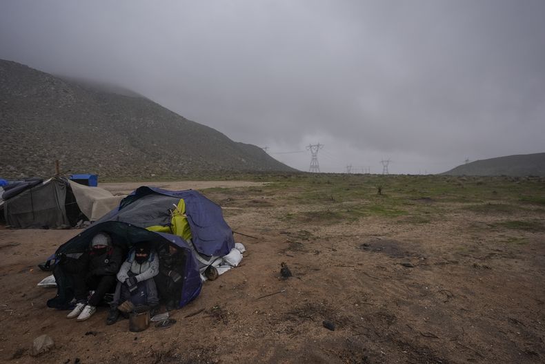 Migrantes de Ecuador solicitantes de asilo acampan para protegerse del viento y la lluvia mientras esperan el proceso, tras cruzar la frontera entre México y Estados Unidos, el 2 de febrero de 2024, cerca de Jacumba, California. Autoridades de Seguridad Nacional de Estados Unidos dijeron el jueves 6 de junio de 2024 que ha aumentado el número de ecuatorianos indocumentados que llegan a su país y advirtió a los migrantes que no se expongan al peligro de los grupos de crimen organizado, especialmente para cruzar el Tapón del Darién. (AP Foto/Gregory Bull)