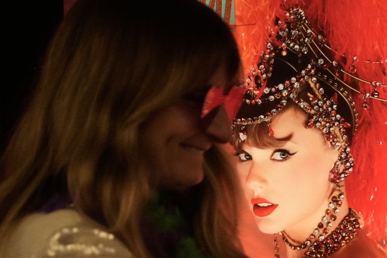 Jenni Boyer cerca de un afiche de Taylor Swift antes del lanzamiento oficial del nuevo álbum de Swift, The Life of a Showgirl, en el AMC Metreon en San Francisco, el viernes 3 de octubre de 2025. (Foto AP/Jeff Chiu)