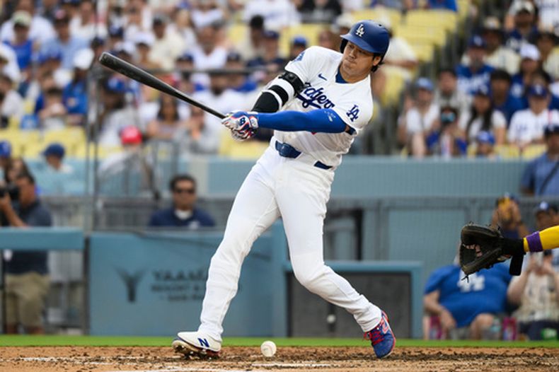 Shohei Ohtani, de los Dodgers de Los Ángeles, conecta una rola (batazo por el suelo) durante la quinta entrada de un partido de béisbol contra los Diamondbacks de Arizona, en Los Ángeles, el domingo 12 de julio de 2026. (Foto AP/Kyusung Gong)