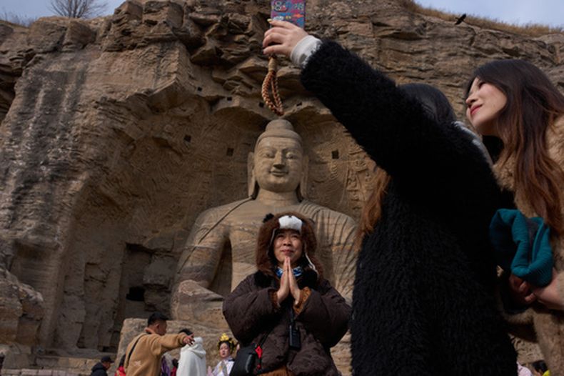 Turistas visitan las cuevas Yungang en Datong, China, el viernes 13 de marzo de 2026. (AP Foto/Ng Han Guan)