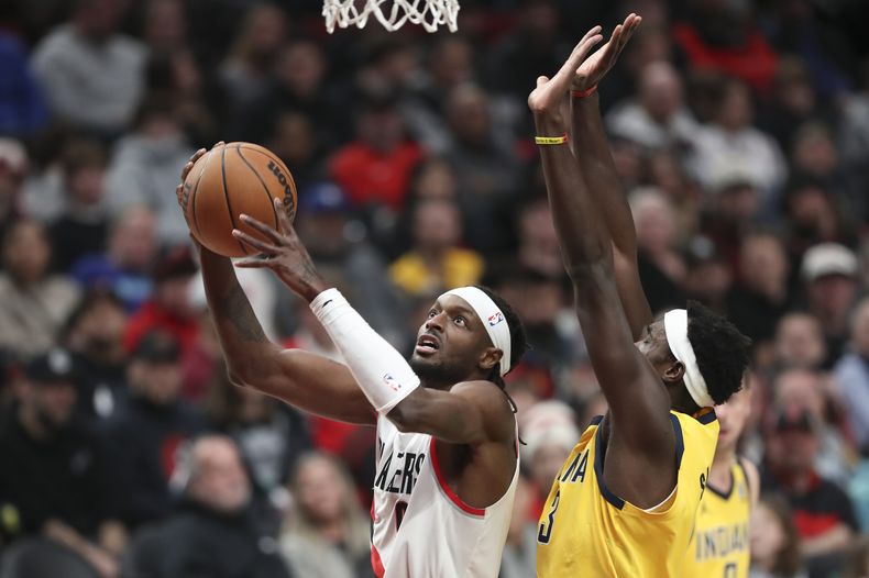 Jerami Grant, de los Trail Blazers de Portland, salta hacia la cesta frente a Pascal Siakam, de los Pacers de Indiana, durante el encuentro del viernes 19 de enero de 2024 (AP Foto/Amanda Loman)