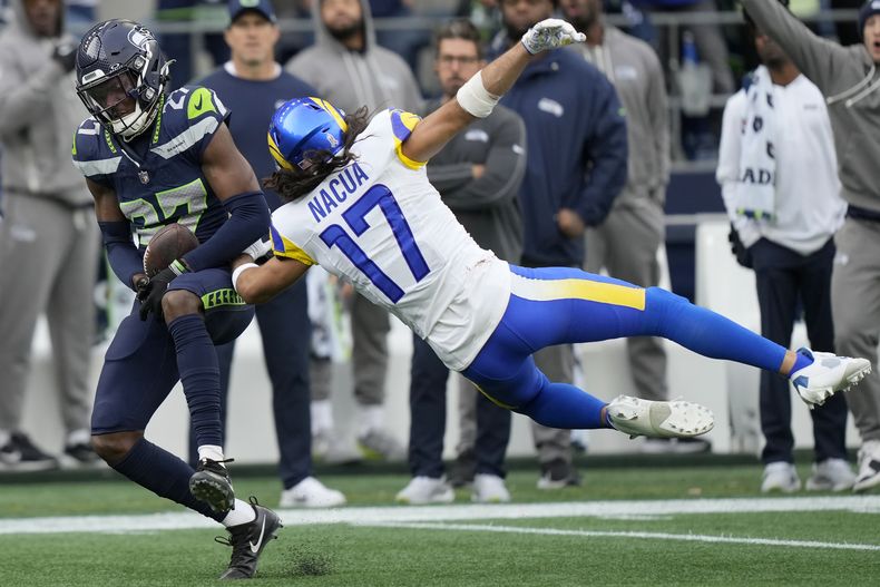 El cornerback de los Seahawks de Seattle, Riq Woolen, a la izquierda, intercepta un pase destinado al wide receiver de los Rams de Los Angeles , Puka Nacua (17), durante la primera mitad en Seattle, el domingo 3 de noviembre de 2024. (AP Foto/Stephen Brashear)
