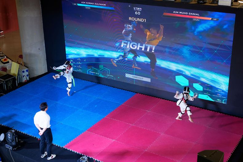 Atletas virtuales de taekwondo compiten en un evento en Kuala Lumpur, Malasia, el sábado 20 de junio de 2026. (Foto AP/Vincent Thian)