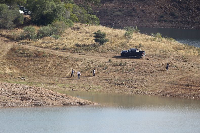 Un equipo policial camina por la orilla del embalse de Arade cerca de Silves, en Portugal, el miércoles 24 de mayo de 2023. Policías portugueses con asistencia de agentes británicos y alemanes reanudaron la búsqueda de Madeleine McCann, una niña británica desaparecida en la región sureña de Algarve hace 16 años. (AP Foto/Joao Matos)