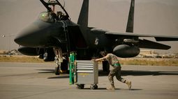 ARCHIVO - Un miembro de la Fuerza Aérea de Estados Unidos pasa empujando un carro por delante de un F-15E Strike Eagle en la Base Aérea de Bagram, en Afganistán, el 17 de octubre de 2009. (AP Foto/Maya Alleruzzo, archivo) ARCHIVO - Un miembro de la Fuerza Aérea de Estados Unidos pasa empujando un carro por delante de un F-15E Strike Eagle en la Base Aérea de Bagram, en Afganistán, el 17 de octubre de 2009. (AP Foto/Maya Alleruzzo, archivo)