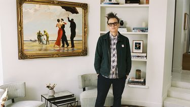 En esta fotografía sin fecha proporcionada por Sothebys, Mark Hoppus de Blink-182 posa junto a la pintura de su colección Crude Oil (Vettriano) de Banksy (2005), que Sothebys subastará el 4 de marzo y parte de las ganancias se destinará a las víctimas de los incendios forestales de Los Ángeles. (Max Montgomery/Sothebys via AP)