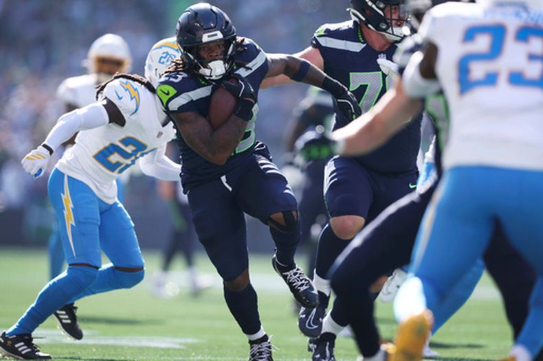 El corredor de los Seahawks de Seattle, Emanuel Wilson (23), avanza por el campo tras una recepción para touchdown durante la primera mitad de un partido de fútbol americano de la NFL contra los Chargers de Los Ángeles, el 4 de octubre de 2026, en Seattle. (Foto AP/Kevin Ng)