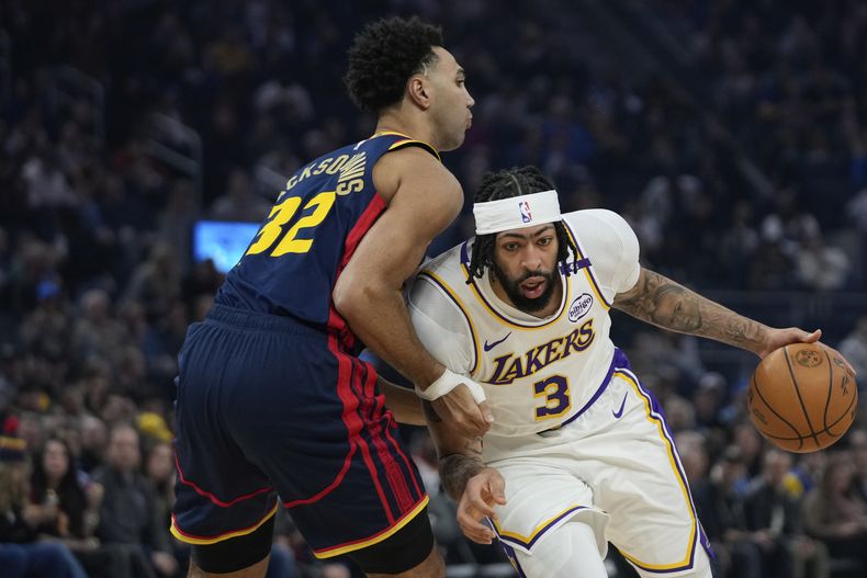 Anthony Davis, alero de los Lakers de Los Ángeles, trata de avanzar frente a Trayce Jackson-Davis, de los Warriors de Golden State, el sábado 25 de enero de 2025 (AP Foto/Godofredo A. Vásquez)