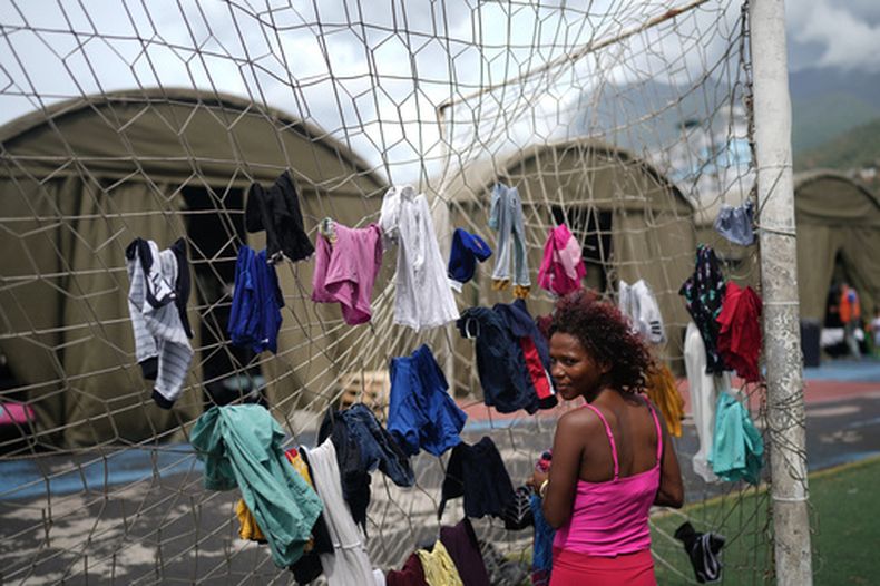 Nataly Mayora cuelga ropa en una portería mientras lava en un complejo deportivo que funge como albergue a personas desplazadas por los sismos, el jueves 9 de julio de 2026, en La Guaira, Venezuela. (AP Foto/Ariana Cubillos)