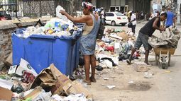Una mujer busca en un contenedor de basura artículos útiles, en La Habana, Cuba, el martes 15 de julio de 2025. (Foto AP/Jorge Luis Baños)