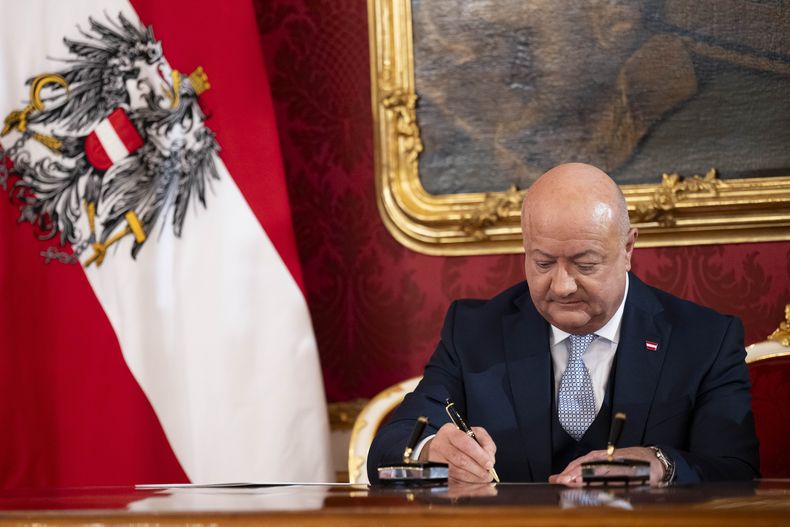 El canciller de Austria, Christian Stocker, firma documentos durante la sesión de investidura del gobierno federal en la planta presidencial en el palacio Hofburg, en Viena, Austria, el lunes 3 de marzo de 2025. (AP Foto/Denes Erdos)