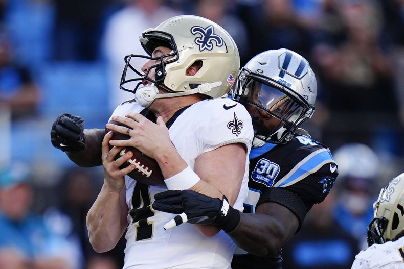 El quarterback de los Saints de Nueva Orleans, Derek Carr, es derribado por el linebacker de los Panthers de Carolina, Charles Harris, en la segunda mitad del partido del domingo 3 de noviembre de 2024, en Charlotte, Carolina del Norte. (AP Foto/Rusty Jones)