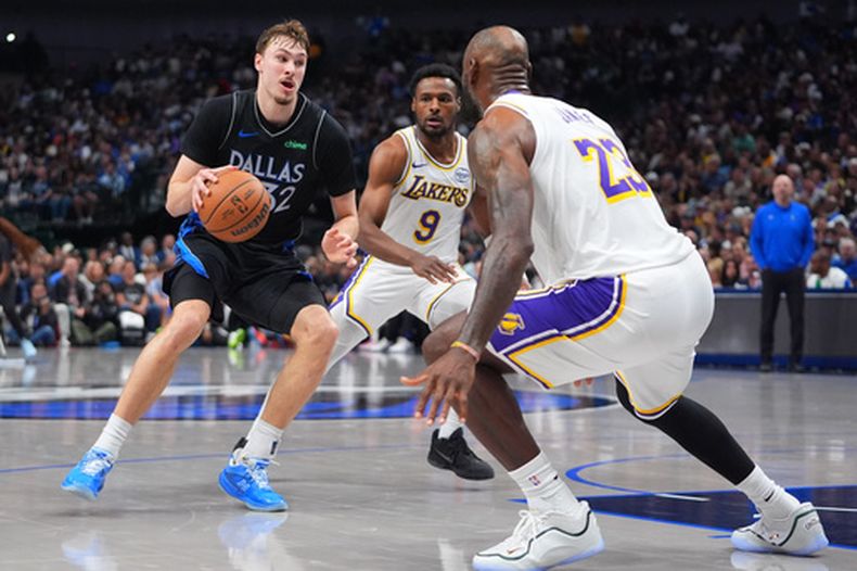 Cooper Flagg (32), de los Mavericks de Dallas, lleva el balón entre LeBron James (23) y Bronny James (9), de los Lakers de Los Ángeles, durante la segunda mitad del juego de baloncesto de la NBA el domingo 5 de abril de 2026, en Dallas. (AP Foto/LM Otero)