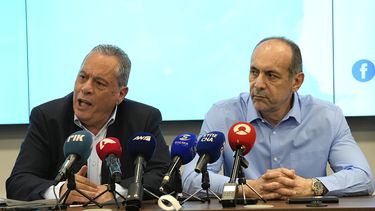 El ministro de Defensa de Chipre, Vasilis Palmas (izquierda), y el de Justicia y Orden Público, Marios Hartsiotis, hablan con reporteros en un centro de coordinación en Larnaca, Chipre, el 17 de marzo de 2025, tras el naufragio de un barco con migrantes en la costa. (AP Foto/Petros Karadjias)