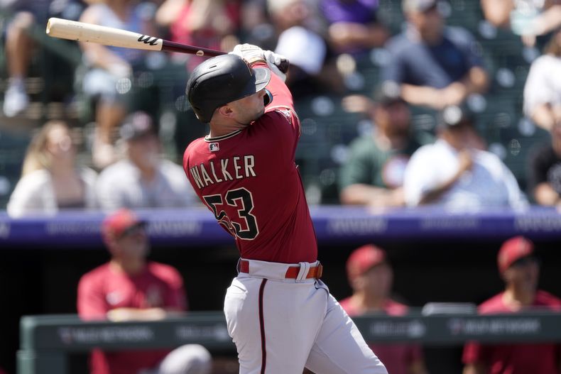 Christian Walker, de los Diamondbacks de Arizona, sigue el vuelo de su cuadrangular de dos carreras en la primera entrada frente al abridor de los Rockies de Colorado, Austin Gomber, en el juego de béisbol del miércoles 16 de agosto de 2023, en Denver. (AP Foto/David Zalubowski)