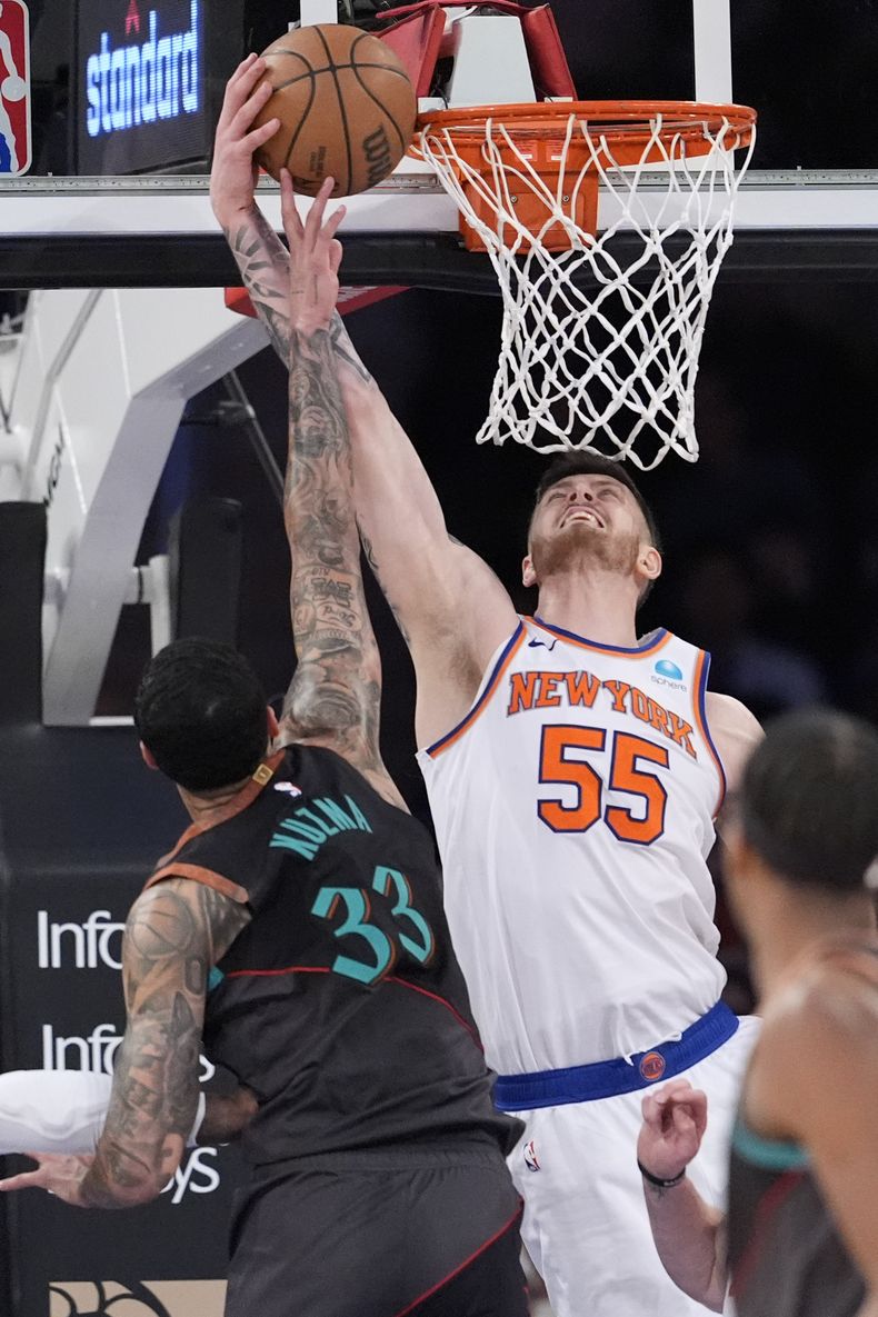 El pívot de los Knicks de Nueva York, Isaiah Hartenstein (55), va a la canasta contra el alero de los Wizards de Washington, Kyle Kuzma (33), en la segunda mitad del partido de baloncesto de la NBA, el jueves 18 de enero de 2024, en el Madison Square Garden de Nueva York. (AP Foto/Mary Altaffer)