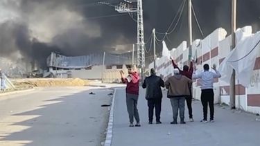 Esta imagen tomada de un video de ITV News muestra a un grupo de cinco hombres que caminan por una calle al oeste de la ciudad meridional de Jan Yunis, en Gaza, mientras levantan las manos y uno ondea una bandera blanca. El ejército israelí ha anunciado que revisará el disparo mortal a uno de los hombres. (ITV News via AP)
