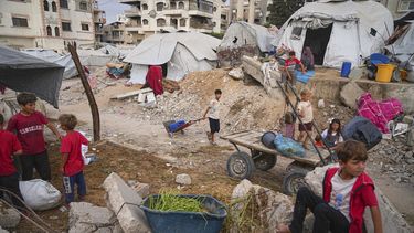 Niños palestinos en un campamento en medio de las ruinas en Ciudad Gaza el 23 de junio del 2025. (AP foto/Jehad Alshrafi)