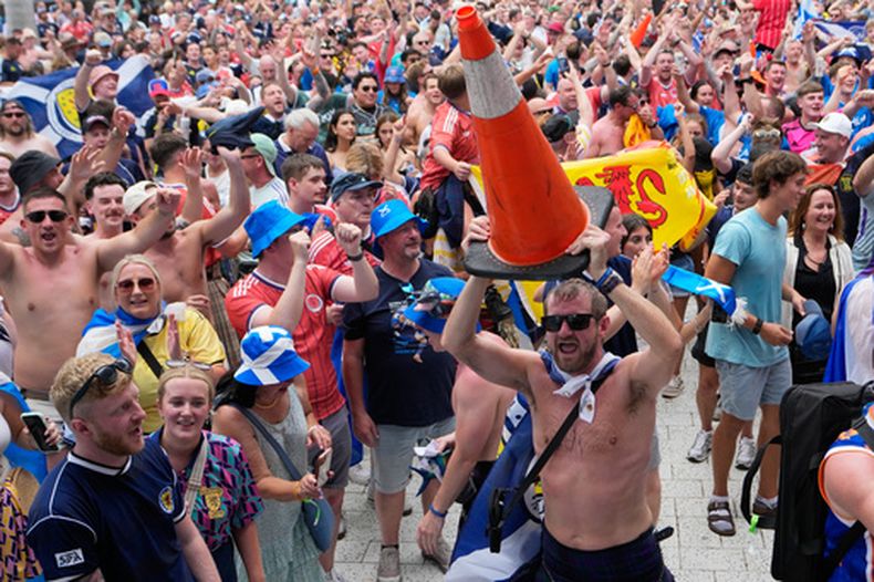 Un aficionado de Escocia baila con un cono de señalización vial como parte de la marcha del llamado Ejército del TArtán frente al loanDepot Park, antes de un juego entre los Marlins de Miami y los Rangers de Texas, el lunes 22 de junio de 2026 (AP Foto/Lynne Sladky)