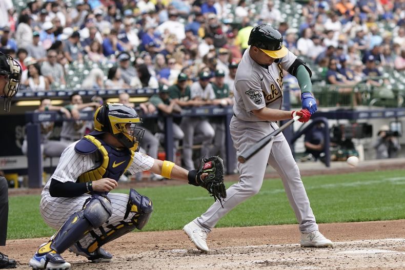 El cubano Aledmys Díaz, de los Atléticos de Oakland, batea un sencillo en el duelo del sábado 10 de junio de 2023, ante los Cerveceros de Milwaukee (AP Foto/Morry Gash)