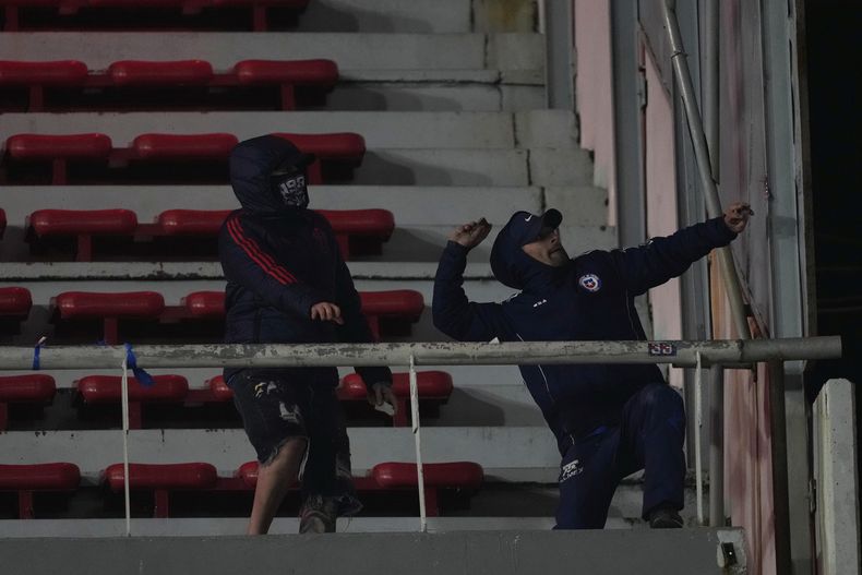 Hinchas de Universidad de Chile lanzan piedras durante un partido de la Copa Sudamericana en cancha de Independiente de Argtnina, el miércoles 20 de agosto de 2025 (AP Foto/Gustavo Garello)