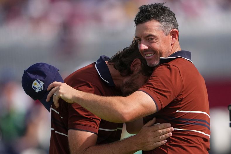 Rory McIlroy y Tommy Fleetwood del equipo de Europa se abrazan tras ganar su duelo en Bethpage Black golf course durante la Copa Ryder el sábado 27 de septiembre del 2025. (AP Foto/Lindsey Wasson)
