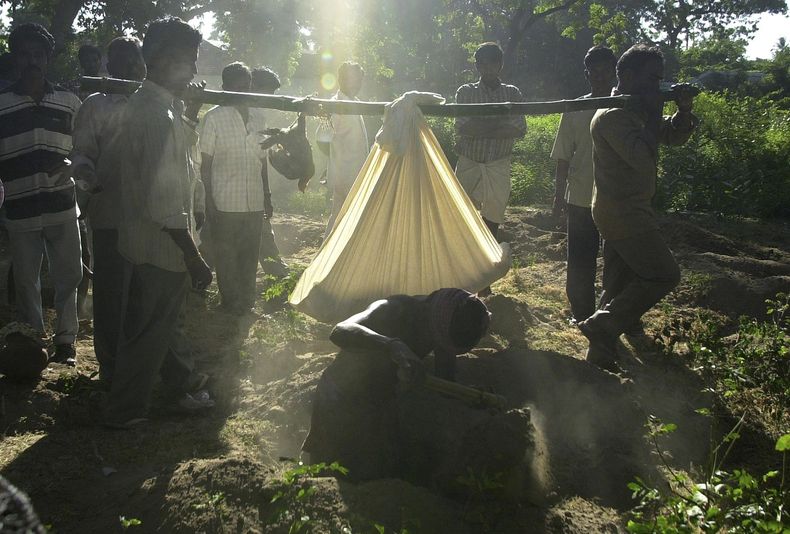 ARCHIVO - En esta foto de archivo del 17 de julio de 2004, parientes cargan el cuerpo de un ni&ntilde;o que muri&oacute; en un incendio que arras&oacute; una escuela primaria en Kumbakonam, India. Una corte conden&oacute; el mi&eacute;rcoles 30 de julio d