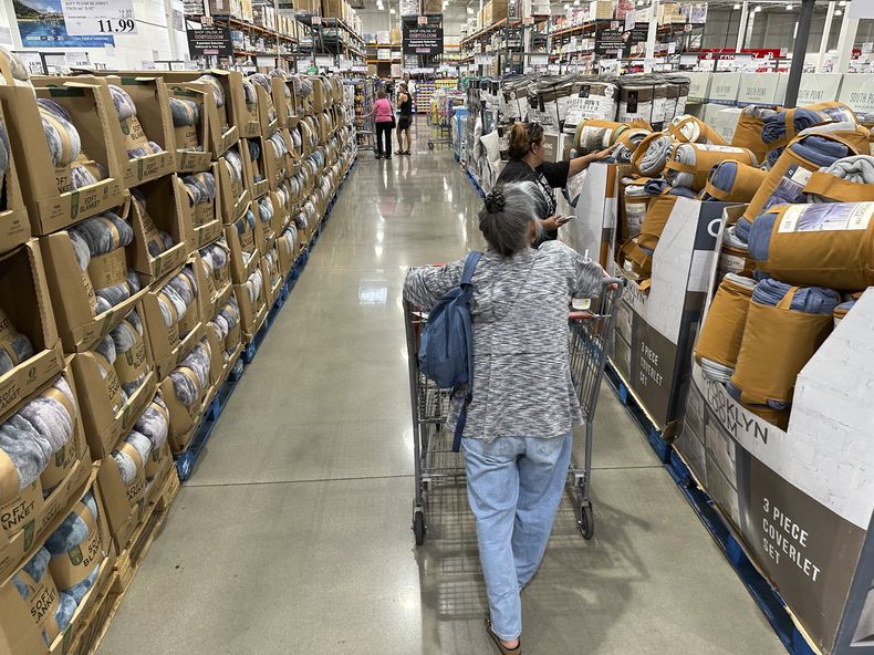 ARCHIVO - Consumidores ven los precios de cobijas a la venta en una tienda de la cadena Costco, el 24 de agosto de 2023, en Sheridan, Colorado. (AP Foto/David Zalubowski, archivo)