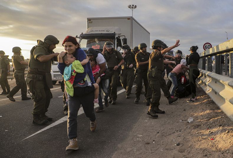Migrantes que bloquean la carretera en la frontera entre Chile y Perú son dispersados por la policía chilena cerca de Arica, Chile, el martes 2 de mayo de 2023. Una crisis migratoria en la frontera entre Chile y Perú se intensificó ante la presencia de migrantes, en su mayoría venezolanos, que están varados en el límite entre ambos países en su ruta de regreso a casa. (AP Foto/Agustín Mercado)